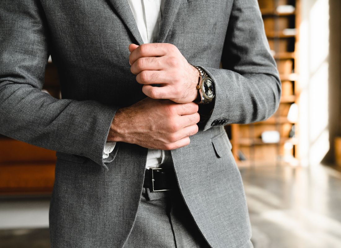 prikaz muškarca u odelu koji stavlja sat na svoju ruku